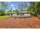 Backyard view of a home featuring mature trees and a stone retaining wall at 11540 Northgate Way, Roswell, GA 30075