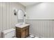 Elegant half bathroom featuring a wood vanity, marble countertop, arch mirror and black-and-white checkered floors at 11540 Northgate Way, Roswell, GA 30075