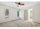 Bright, neutral bedroom with a ceiling fan, two windows, and a gray carpet at 11540 Northgate Way, Roswell, GA 30075