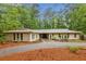Inviting one-story house with a gravel driveway and mature trees at 11540 Northgate Way, Roswell, GA 30075