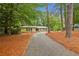 Attractive front exterior of home with long driveway and lots of trees at 11540 Northgate Way, Roswell, GA 30075