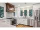 Renovated kitchen boasts stainless steel appliances, white cabinets, marble countertops and hardwood floors at 11540 Northgate Way, Roswell, GA 30075