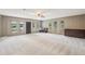 Spacious living room featuring large windows, neutral carpet, and a ceiling fan at 11540 Northgate Way, Roswell, GA 30075