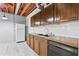 A kitchen with dark wood cabinets, a white refrigerator, and gray vinyl floors at 1725 Timberland Ne Rd, Atlanta, GA 30345