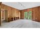 Bright living room featuring wood-paneled walls, hardwood floors, and a window overlooking a lush green landscape at 1725 Timberland Ne Rd, Atlanta, GA 30345