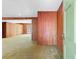 Spacious living room with wood paneled walls, carpet and plenty of natural light. Door to porch at 1725 Timberland Ne Rd, Atlanta, GA 30345