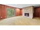 Inviting living room with a brick fireplace, wood paneling, carpet and a large picture window at 1725 Timberland Ne Rd, Atlanta, GA 30345