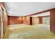 Large living room featuring wood paneling, expansive layout, carpet and natural light through large windows at 1725 Timberland Ne Rd, Atlanta, GA 30345