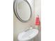Neat powder room featuring a pedestal sink, round mirror, and a colorful striped towel, adding a touch of charm at 215 Semel Nw Dr # 455, Atlanta, GA 30309