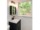 Bathroom featuring a modern vanity, unique mirror, and window view to the outdoors at 2840 Wendy Ln, Marietta, GA 30062