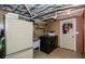 Laundry room with wood paneled walls, black washing machine, utility sink, and white refrigerator at 2840 Wendy Ln, Marietta, GA 30062