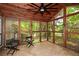Screened sunroom featuring a wood ceiling, tile floor, and views of the surrounding lush greenery at 2840 Wendy Ln, Marietta, GA 30062
