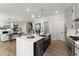 Open kitchen with stainless steel appliances, farmhouse sink, and view of the staircase and living room at 3552 Cedarvale Ct, Powder Springs, GA 30127