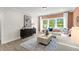 Cozy living room featuring a comfortable white couch, modern decor, and natural light from large windows at 3552 Cedarvale Ct, Powder Springs, GA 30127