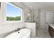 Main bathroom with a soaking tub, glass shower, and a large window at 3552 Cedarvale Ct, Powder Springs, GA 30127