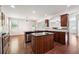 Open kitchen features an island, stainless steel appliances, and hardwood flooring at 5705 Aspen Dr, Cumming, GA 30040