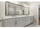 Bathroom featuring double sink vanity with white cabinets, marble tile flooring, and a walk-in shower at 1417 Coretta Scott Bnd, Atlanta, GA 30318