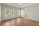 A bright, empty bedroom with hardwood floors, neutral walls, and french doors at 1417 Coretta Scott Bnd, Atlanta, GA 30318