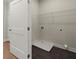 Functional laundry room with dark tile flooring, storage shelf, and utility connections at 1417 Coretta Scott Bnd, Atlanta, GA 30318