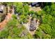Aerial view of the home showcasing its setting amongst the trees, driveway, and backyard features at 2025 Goldmine Dr, Cumming, GA 30040