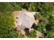 Aerial view captures the home amidst lush greenery and mature trees, highlighting outdoor living spaces at 2025 Goldmine Dr, Cumming, GA 30040