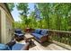 Outdoor living space with wicker seating, table, grill, and a wooded view at 2025 Goldmine Dr, Cumming, GA 30040
