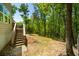 Backyard deck with steps to the lush yard, a mix of grass, trees and wooded views at 2025 Goldmine Dr, Cumming, GA 30040