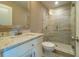 Bathroom with tiled shower, glass door, white vanity with marble countertop and light fixtures at 2025 Goldmine Dr, Cumming, GA 30040