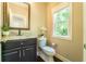 Charming powder room featuring a granite countertop, decorative mirror, and modern fixtures at 2025 Goldmine Dr, Cumming, GA 30040