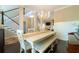 Open-concept dining area boasts a long table, bench seating, and modern chandelier at 2025 Goldmine Dr, Cumming, GA 30040