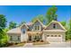 Charming two-story home features an attached two-car garage, and inviting covered entryway with rocking chairs at 2025 Goldmine Dr, Cumming, GA 30040