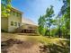 Back exterior view of home with lawn, deck, and wooded views at 2025 Goldmine Dr, Cumming, GA 30040