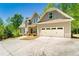 Well-maintained home with a spacious driveway, two-car garage, and lush green trees in a serene setting at 2025 Goldmine Dr, Cumming, GA 30040
