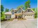Charming two-story home featuring a manicured lawn, two-car garage, and inviting front porch with stylish decor at 2025 Goldmine Dr, Cumming, GA 30040