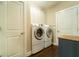 Convenient laundry room featuring a front load washer, dryer, and ample storage cabinets at 2025 Goldmine Dr, Cumming, GA 30040