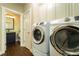 Functional laundry room with modern front load machines and built-in storage at 2025 Goldmine Dr, Cumming, GA 30040