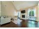 Bright living room featuring a fireplace, hardwood floors, and a cozy sectional sofa at 2025 Goldmine Dr, Cumming, GA 30040