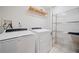 Functional laundry room with modern washer, dryer, and shelving at 3 Fairway Nw Dr, Kennesaw, GA 30144