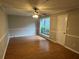 Living room with laminate flooring, ceiling fan, window, and a painted white door at 3 Fairway Nw Dr, Kennesaw, GA 30144