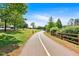 Scenic walking path with trees, a wooden fence, and green spaces, ideal for leisurely strolls at 3321 Hampreston Nw Way, Kennesaw, GA 30144