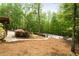 Well-maintained backyard with a fenced pool, patio area, and a slide set amongst mature trees at 1400 Squire Ln, Cumming, GA 30041