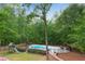 Scenic backyard featuring a fenced pool, a slide set, and surrounded by lush greenery and mature trees at 1400 Squire Ln, Cumming, GA 30041