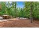 Secluded backyard featuring an in-ground pool with mature trees, flowering bushes and an adjacent walkway at 1400 Squire Ln, Cumming, GA 30041