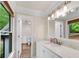 Bright bathroom features white cabinets, marble countertop, and modern light fixture at 1400 Squire Ln, Cumming, GA 30041