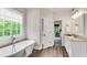 This bright bathroom features a soaking tub with a large window at 1400 Squire Ln, Cumming, GA 30041