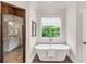 Bright bathroom featuring soaking tub, and glass-enclosed shower at 1400 Squire Ln, Cumming, GA 30041