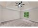 Spacious bedroom featuring tray ceiling, a ceiling fan and large window at 1400 Squire Ln, Cumming, GA 30041