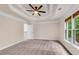 Spacious bedroom featuring a tray ceiling, neutral paint, and access to other rooms of the house at 1400 Squire Ln, Cumming, GA 30041