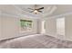 Spacious bedroom featuring a tray ceiling, neutral paint, and walk in closet at 1400 Squire Ln, Cumming, GA 30041