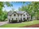 Beautiful home showcasing a well-maintained lawn, elegant architecture, and a driveway leading to a two-car garage at 1400 Squire Ln, Cumming, GA 30041